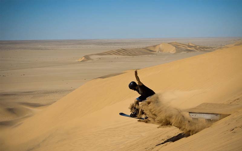 катание на санках по песчаным дюнам 