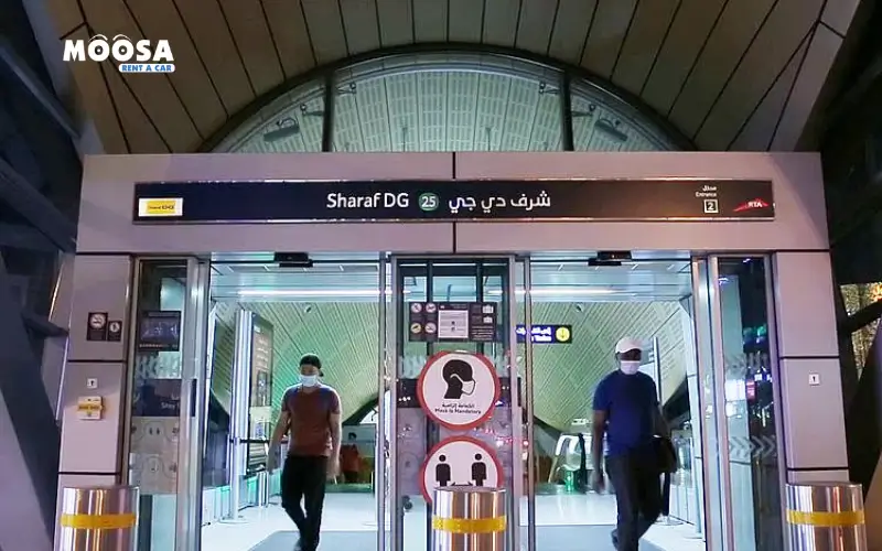 Entrance of the Fahidi Metro Station rename as Sharaf DG Metro Station in Dubai, with passengers wearing masks and signs for safety protocols.